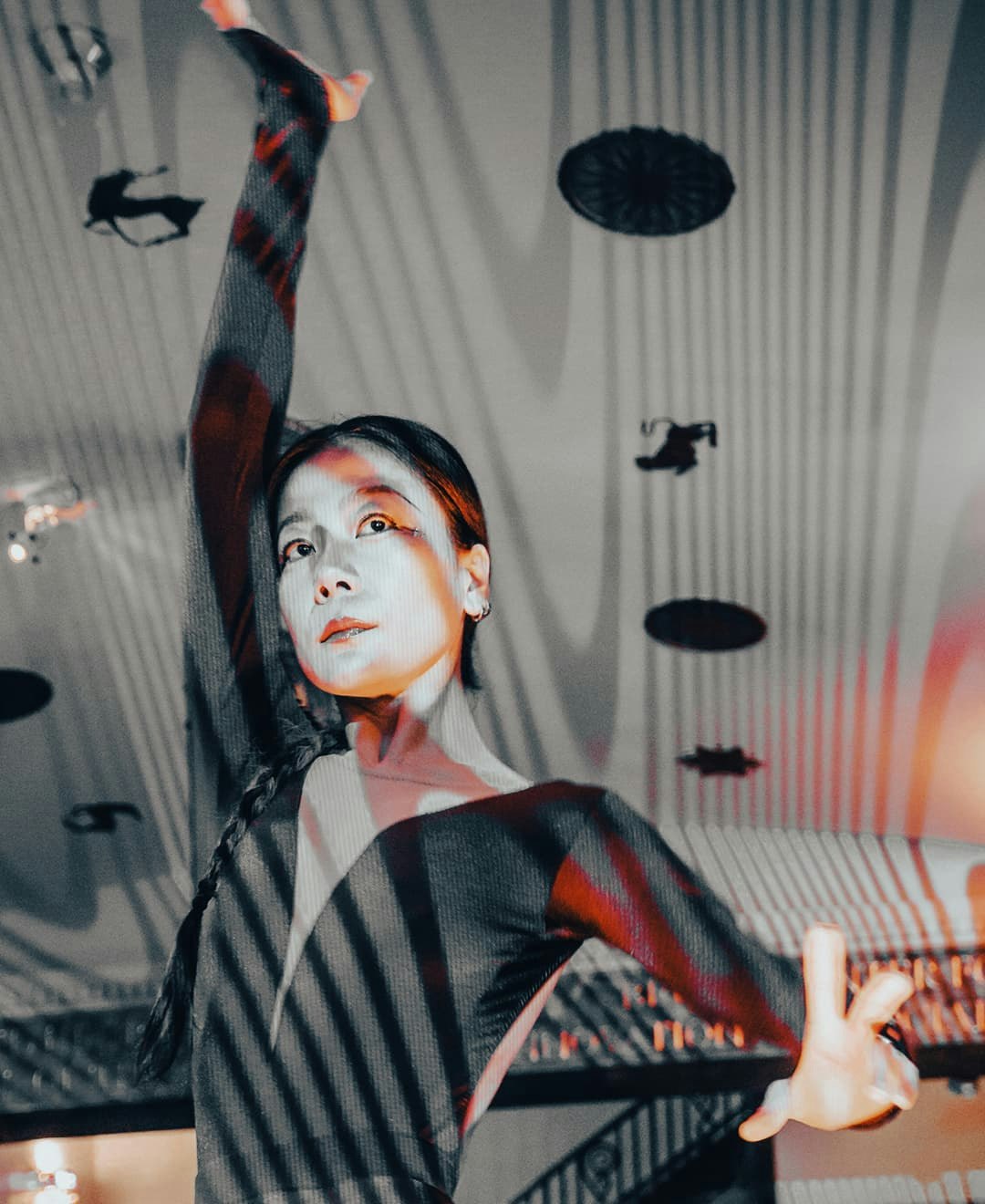 This is a close-up portrait of a woman with dark hair and fair skin, likely in the midst of a dance performance